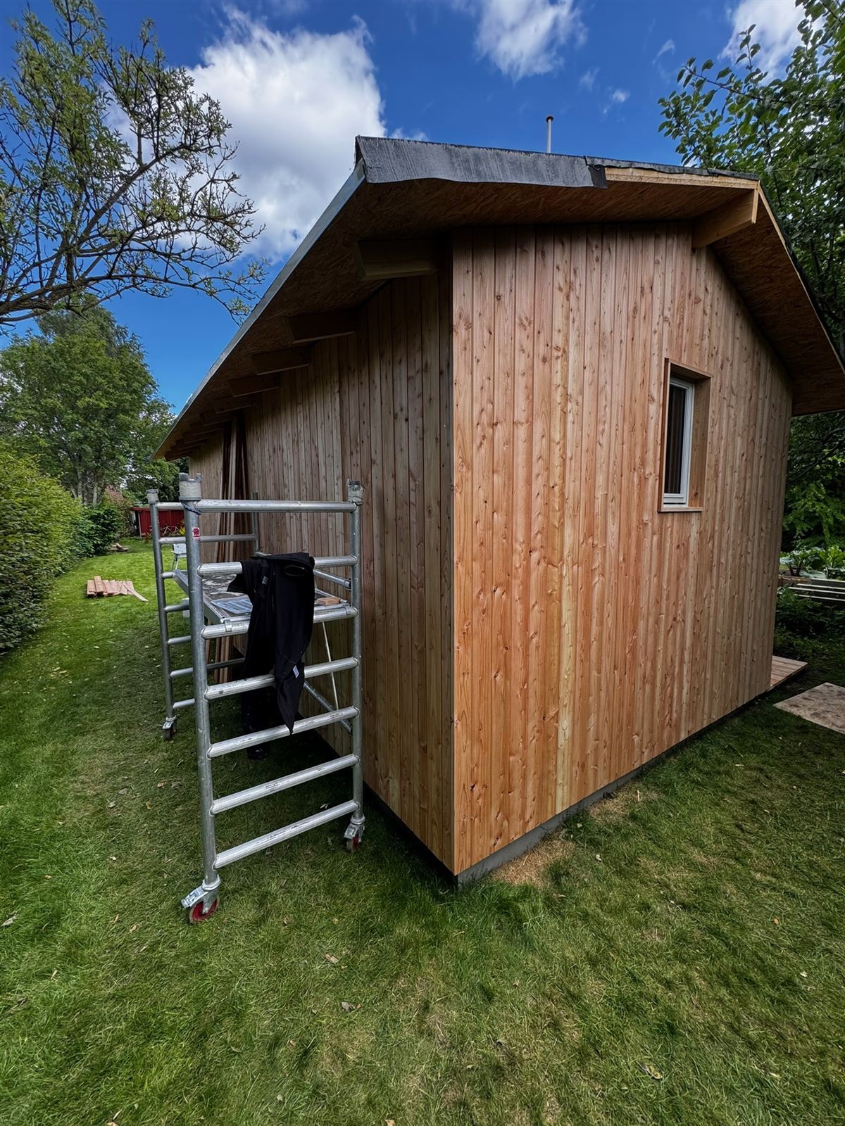 Skur beklædt med cedertræ mod blå himmel